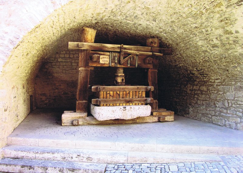 Der historische Weinkeller von 1767 mit alter Weinpresse unter dem Backsteingewölbe
